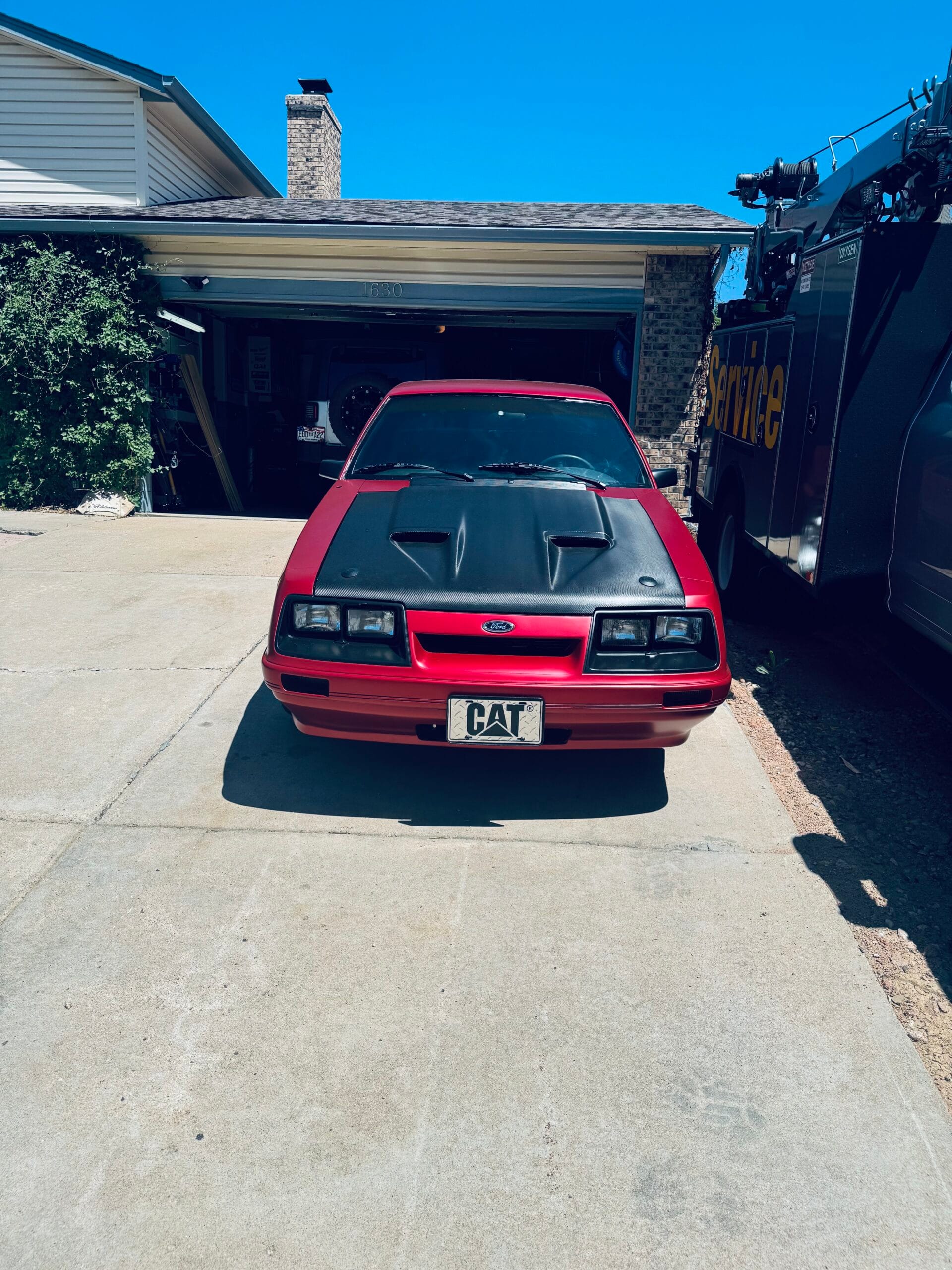 1986 Mustang LX Foxbody coupe restomod in satin vampire red at Aurora, Colorado driveway