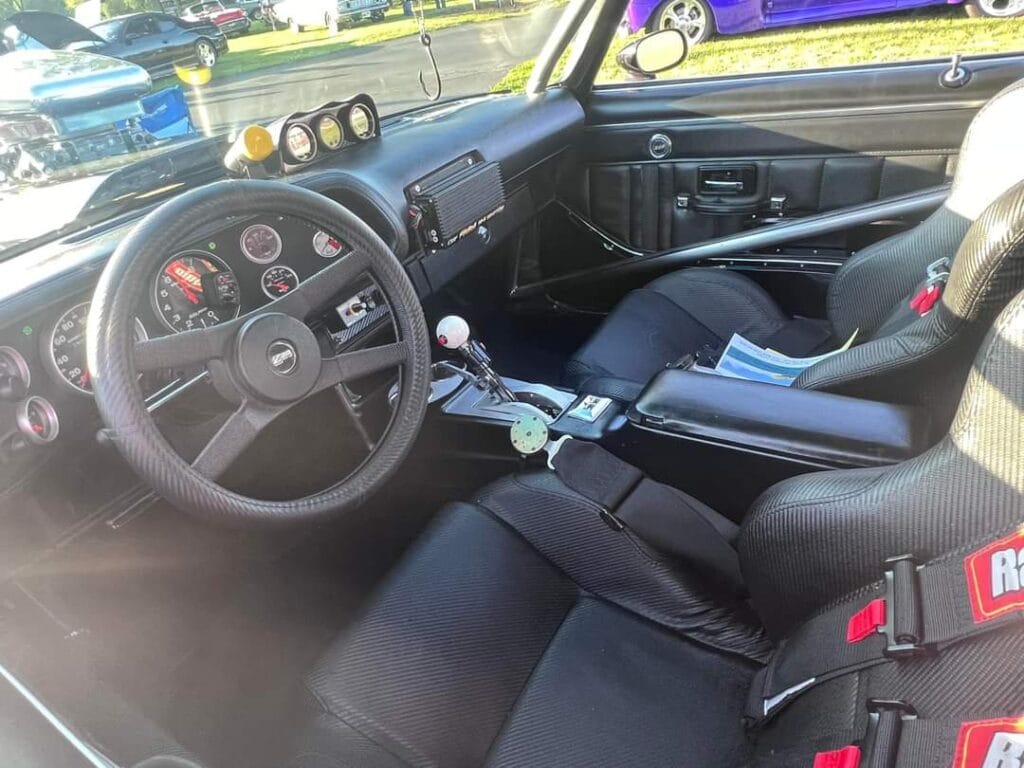 Interior of the Pandemic 1980 Camaro Z28 showing race bucket seats, roll cage, AutoMeter gauges, performance shifter, and street/strip cockpit layout.